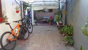 圣米格尔·德·图库玛Albergue Casa Elena的停在植物丛中的建筑旁边的橘子自行车