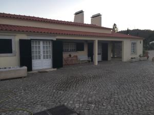 塞图巴尔Casa do Jardim的前面有砖瓦车道的房子