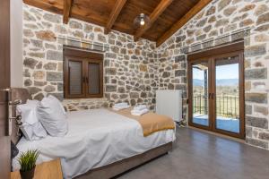 波利兹罗松Raise Polydrosos Alpine Escape的一间卧室设有一张床和石墙