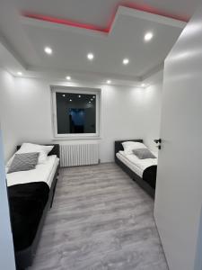 诺德施泰特Wohnung am Norderstedt Stadtpark的一间卧室设有两张床,墙上配有电视。