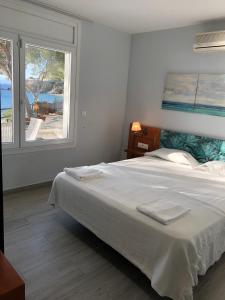 罗萨斯Veuràs el Mar - Almadrava Beach House的卧室配有一张大白色床和窗户