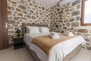 波利兹罗松Raise Polydrosos Alpine Escape的石墙卧室配有一张带毛巾的床