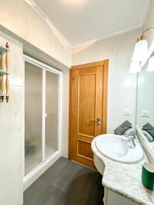 拉雷多Apartamento en Costa de Cantabria, Laredo的一间带水槽和玻璃门的浴室