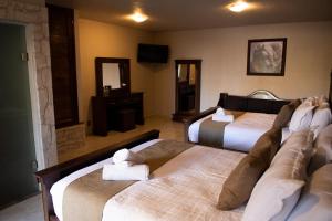 贝纳尔Hotel Boutique Sacramento的酒店客房设有两张床和电视。