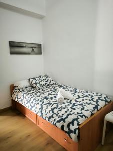 格拉纳达La casita de Lyra的一张位于一间白色和黑色毯子的房间内的床铺