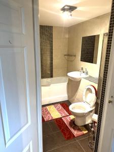 伦敦London O2 ARENA COOL BREEZE HOUSE的浴室配有卫生间、浴缸和水槽。