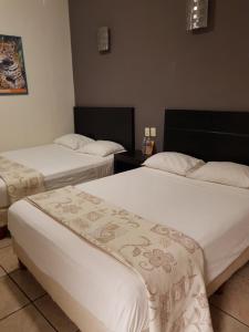 图斯特拉古铁雷斯Ukeinn centro的酒店客房,配有两张带白色床单的床