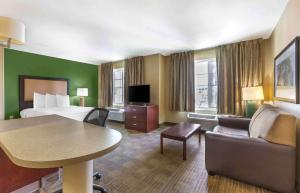 凤凰城美国长住酒店 - 凤凰城中心的酒店客房配有床、沙发和桌子。