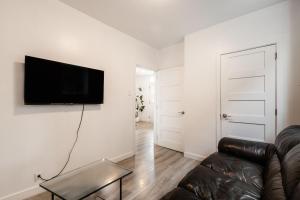 蒙特利尔Appartement 1 chambre-1011的客厅配有沙发和墙上的电视