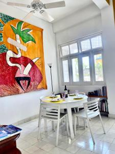 卡塔赫纳Bello apartamento corazón de Cartagena colonial的一间设有桌子和墙上绘画的用餐室