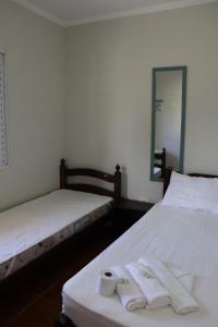 博拉塞亚Camping Pousada Ilha do Mel - Frente ao Mar的配有2张床的客房,提供毛巾和镜子