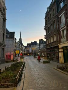 鲁昂Le Marguerite & Le Mélange Savant的城市中一条空荡荡的街道,有建筑