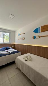 苏巴乌马Apartamento Doce Lar Resort Treebies Subauma的一间卧室设有两张床,墙上设有冲浪板。