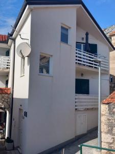 格拉达茨Apartments by the sea Gradac, Makarska - 15642的白色房子的一侧设有阳台