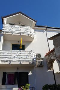 格拉达茨Apartments by the sea Gradac, Makarska - 15642的白色的建筑,带有黄色旗帜的阳台