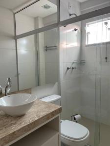 邦比尼亚斯Muito confortável, vista do mar, todo climatizado的一间带水槽、卫生间和玻璃淋浴间的浴室