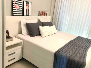 邦比尼亚斯Muito confortável, vista do mar, todo climatizado的卧室配有白色床和白色梳妆台