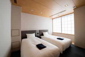 大阪Welina Hotel Premier Osaka Namba的两张睡床彼此相邻,位于一个房间里