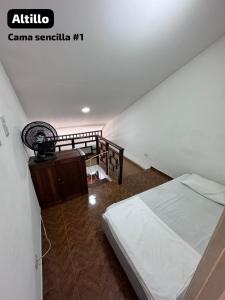 卡塔赫纳Encanto en Cartagena, aparatamento Duplex con vista al mar的一间卧室配有一张床,楼梯配有风扇