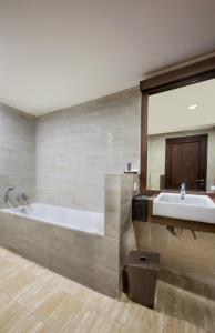 日惹Riss Hotel Malioboro的带浴缸和盥洗盆的大浴室