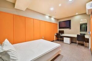 釜山釜山顶级汽车旅馆的一间卧室配有一张床、一张书桌和一台电视