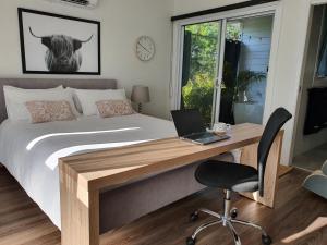斯普林伍德Luxury private guest suite in the Blue Mountains的一间卧室配有一张床和一张带笔记本电脑的书桌