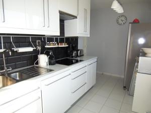 阿卡雄Appartement Arcachon, 3 pièces, 4 personnes - FR-1-374-34的厨房配有白色橱柜、水槽和冰箱。