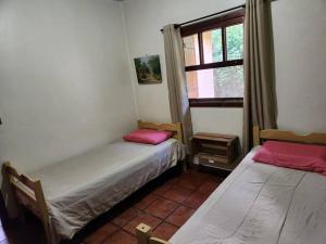 新弗里堡Casa Chalé Chácara Caminho do Vale的带窗户的客房内的两张床