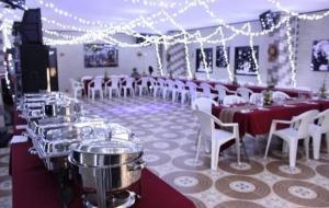 里奥内格罗HOTEL PARADISE RIONEGRO的宴会厅配有桌子、白色椅子和灯