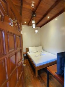 邦劳Glorias Panglao Inn 1的一间小卧室,配有一张床和一扇门