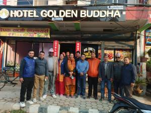 拉明德HOTEL GOLDEN BUDDHA的一群站在酒店金色佛塔前的人