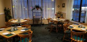 加纳诺克Riviera Inn And Suites 1000 Islands的用餐室设有桌椅和窗户。