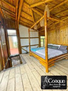 莫姆皮切Coaque black Mompiche的稻草小屋内一间卧室,配有一张床