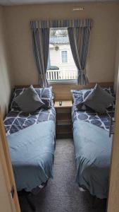 Porchfield51 Oaklands caravan park dean thorness bay cowes的小型客房 - 带2张床和窗户