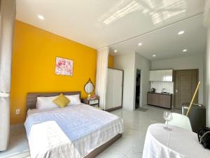胡志明市Luxury Condotel Sai Gon 3的一间卧室设有一张床和黄色的墙壁