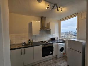 伦敦Apartment Near Towerbridge的厨房配有水槽和洗衣机