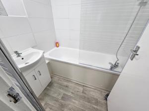 伦敦Apartment Near Towerbridge的白色的浴室设有浴缸和水槽。