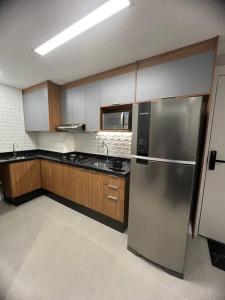 圣保罗Apto novinho na Barra Funda próximo Allianz I的厨房配有不锈钢冰箱和木制橱柜
