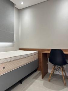圣保罗Apto novinho na Barra Funda próximo Allianz I的一间卧室配有一张床、一张桌子和一把椅子