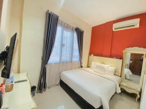 棉兰JIYO BOUTIQUE HOTEL by SAJIWA的卧室配有白色的床和红色的墙壁