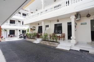 库塔巴厘岛城市花园德维帕酒店的白色的建筑,里面摆放着桌椅