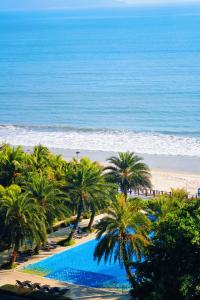 汕尾汕尾保利希尔顿逸林酒店的享有棕榈树海滩和游泳池的景色