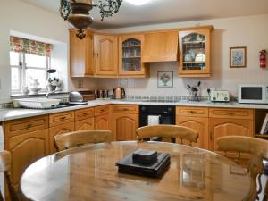 TetneyButtermilk Cottage - Uk46270的厨房配有木制橱柜和桌椅
