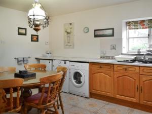 TetneyButtermilk Cottage - Uk46270的厨房配有桌子和洗衣机。