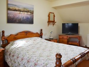 TetneyButtermilk Cottage - Uk46270的一间卧室配有一张床和一台平面电视