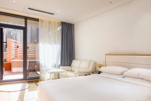 釜山侬新酒店的卧室配有床、椅子和窗户。