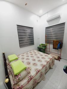 Padang RengasAufa House的一间卧室配有一张带绿毛巾的床