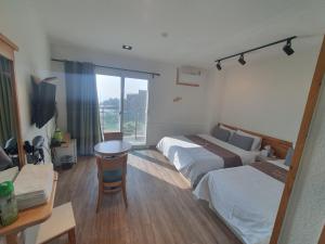 仁川市Hotel Oceanview的酒店客房配有两张床和一张书桌