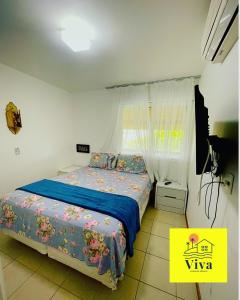 格拉瓦塔Apto GRAVATÁ ASA BRANCA D12 04的一间卧室配有一张带蓝色毯子的床和窗户。