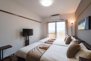 那霸KINTARO Hotel Okinawa Naha的卧室配有一张大白色床和窗户